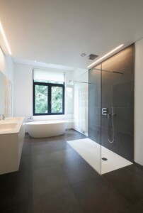 Renoviertes Badezimmer mit Barrierefreier Dusche, Badewanne, Heizung und Waschtisch.