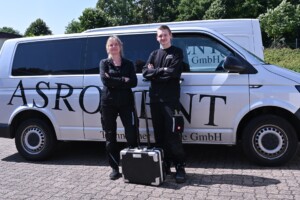 Mitarbeitende stehen vor einem ASRODENT Transporter