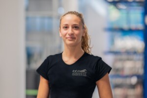 Mitarbeiterin steht in der Lagerhalle vor den Regalen.