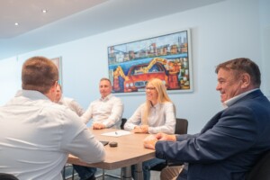 Teambesprechung im Konferenzraum mit mehreren Mitarbeitenden.